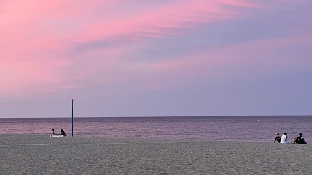 Ciel rose et baigneurs au crépuscule sur la plage de La Casita